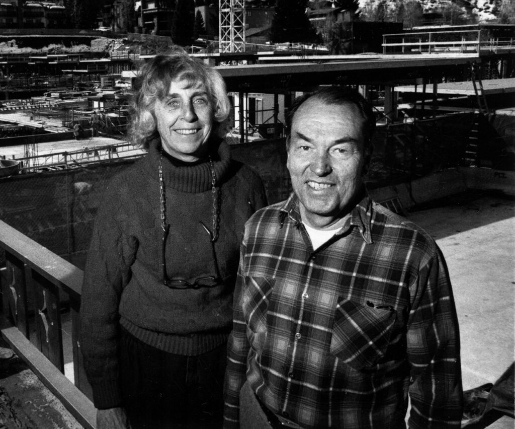 One b/w photograph of Marian and Ralph Melville, owners of the Mountain Chalet Hotel on Durant St., 1990. This photo appears on page 297 of Mary Eshbaugh Hayes' book "The Story of Aspen" with the caption "Marian and Ralph Melville stand on a balcony that now overlooks construction of the 295,000-square-foot Ritz Carlton." The Ritz Carlton is now the St. Regis Hotel.